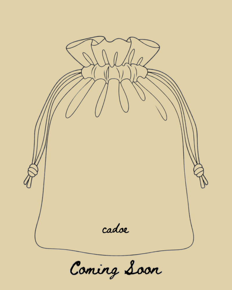 Black line art outline of a drawstring pouch on a white background, with the brand 'cadoe' and the text 'Coming Soon' below.